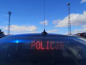 Zdjęcie tylnej szyby radiowozu nieoznakowanego z wyświetlonym napisem &quot;Policja&quot;.