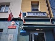 Zdjęcie wejścia do budynku komisariatu, nad którym widoczny jest baner Policja.