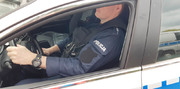 Zdjęcie umundurowanego policjanta jadaącego radiowozem