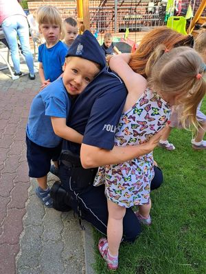 Dzieci przytulające się do umundurowanej policjantki
