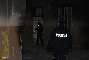 Dwóch umundurowanych policjantów w ciemnym pustostanie