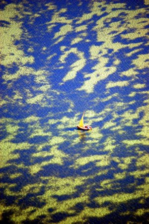 kolaż fotograficzny - żaglówka na wodzie widziana z lotu ptaka