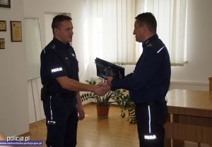 Zdjęcie przedstawiające policjanta odbierającego podziękowania od Komendanta KPP w Głogowie