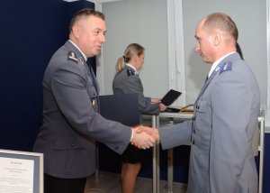 Zdjęcie przedstawiające jednego z laureatów konkursu, przyjmującego podziękowania od Komendanta Wojewódzkiego Policji zs. w Radomiu insp. Tomasza Michułki