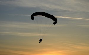 Zdjęcie przedstawiające lecącego paralotniarza