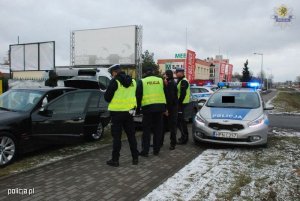 Zdjęcie przedstawiające funkcjonariuszy policji wykonujących czynności służbowe na drodze