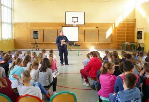 Zdjęcie przedstawiające dzielnicowego podczas spotkania z dziećmi w szkole podstawowej