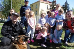 Zdjęcie przedstawiające funkcjonariuszy Policji podczas prezentacji przedszkolakom psa służbowego