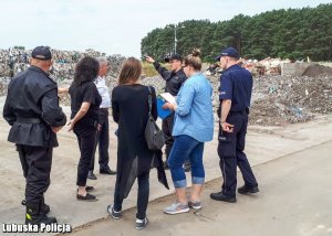 Zdjęcie przedstawiające policjanta oraz pracowników ochrony środowiska podczas kontroli wysypiska śmieci