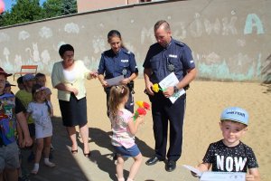 Zdjęcie przedstawiające dwójkę umundurowanych policjantów na spotkaniu z dziećmi w szkole