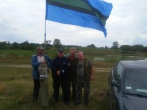 Zdjęcie przedstawiające dzielnicowego z wędkarzami