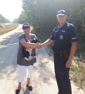 Zdjęcie przedstawiające policjanta odbierającego podziękowania od właścicielki odnalezionego psa