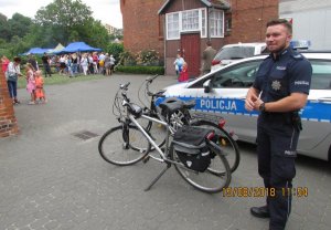 Zdjęcie przedstawiające policjanta stojącego przy rowerach