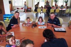 Zdjęcie przedstawiające policjantów podczas spotkania z dziećmi z kolonii