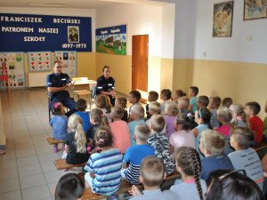 Zdjęcie przedstawiające dzielnicowego podczas pogadanki w szkole z dziećmi