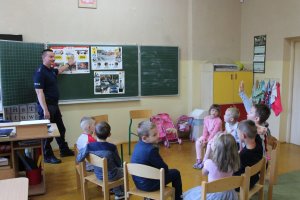 Zdjęcie przedstawiające dzielnicowego podczas spotkania z dziećmi w szkole