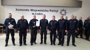 Zdjęcie przedstawiające policjantów, stojących z pucharami