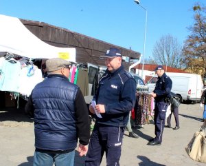 Zdjęcie przedstawiające policjanta rozmawiającego z obywatelem