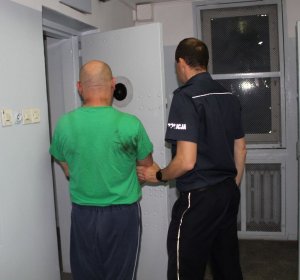 Zdjęcie przedstawiające policjanta z zatrzymanym
