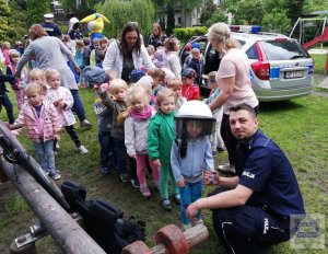 Zdjęcie przedstawiające policjanta z przedszkolakami