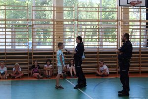 Zdjęcie przedstawiające policjantów udzielających młodzieży instrukcji na temat bezpieczeństwa podczas spędzania wolnego czasu nad wodą