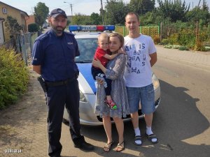 Zdjęcie przedstawiające policjanta umundurowanego policjanta stojącego z rodzicami chorego Pawełka