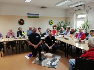 Zdjęcie przedstawiające dwójkę policjantów wraz z grupą seniorów