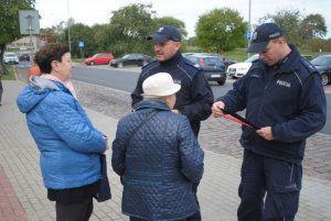 Zdjęcie przedstawiające policjantów rozdających ulotki