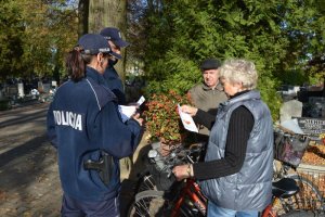 Zdjęcie przedstawiające policjantów rozdających seniorom ulotki