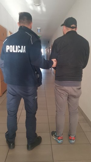 Zdjęcie przedstawiające policjanta z osoba zatrzymaną