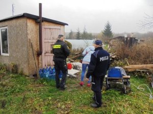 Zdjęcie przedstawiające policjanta wraz ze funkcjonariuszem Straży Miejskiej dokonujących kontroli pustostanu