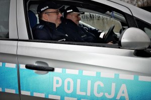 Zdjęcie przedstawiające dwójkę policjantów siedzących w radiowozie