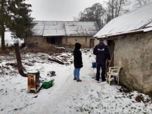 Zdjęcie przedstawiające policjanta dokonującego kontroli zaniedbanego budynku mieszkalnego