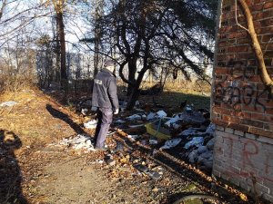 Zdjęcie przedstawiające policjanta stojącego obok pustostanu