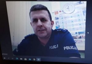 Zdjęcie przedstawiające policjanta prowadzącego połączenie wideo