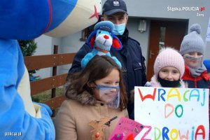 Zdjęcie przedstawiające policjanta stojącego wraz z uczniami, którzy zorganizowali spotkanie