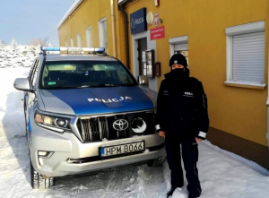 Zdjęcie przedstawiające policjantkę stojącą przy radiowozie