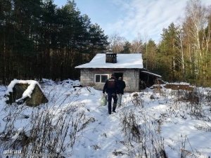 Zdjęcie przedstawiające policjanta idącego z mężczyzną w kierunku domu