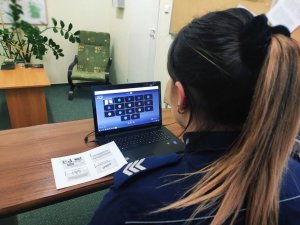 Zdjęcie przedstawiające policjantkę siedzącą przed komputerem
