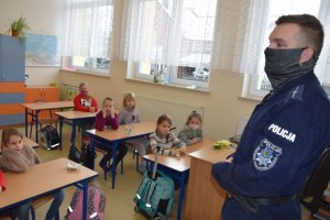 Zdjęcie przedstawiające policjanta podczas spotkania z dziećmi w klasie