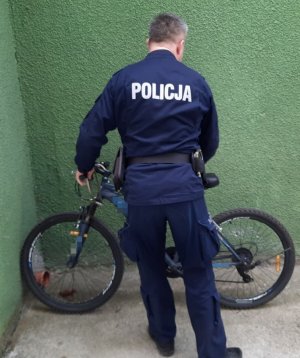 Zdjęcie przedstawiające policjanta z rowerem