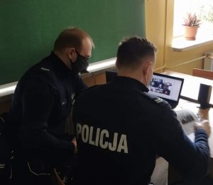 Zdjęcie przedstawiające dwójkę policjantów siedzących przy laptopie