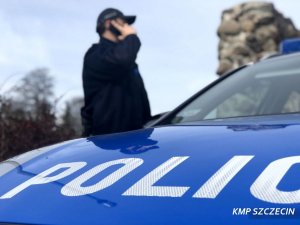 Zdjęcie przedstawiające policjanta rozmawiającego przez telefon komórkowy