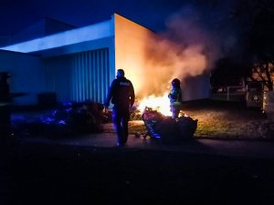 Zdjęcie przedstawiające policjanta stojącego obok płomieni ognia