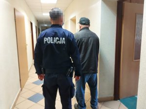 Zdjęcie przedstawiające policjanta stojącego z osobą zatrzymaną