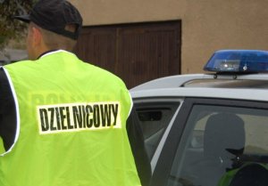 Zdjęcie przestawiające policjanta w żółtej kamizelce odblaskowej z napisem dzielnicowy