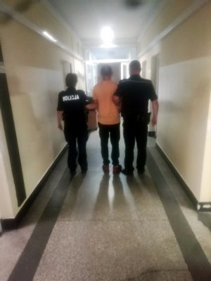 Zdjęcie przedstawiające policjantów stojących z osobą zatrzymaną