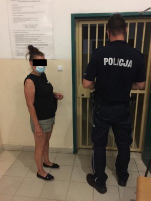 Zdjęcie przedstawiające policjanta stojącego z osobą zatrzymaną