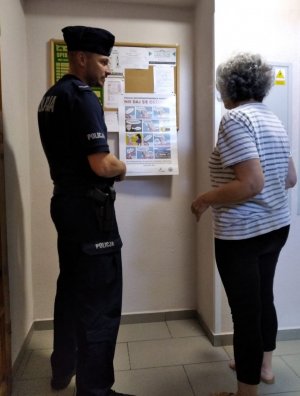 Zdjęcie przedstawiające policjanta stojącego ze starszą osobą