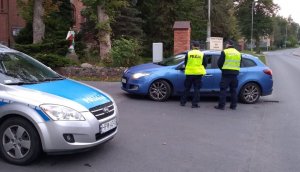 Policjanci stojący obok pojazdu